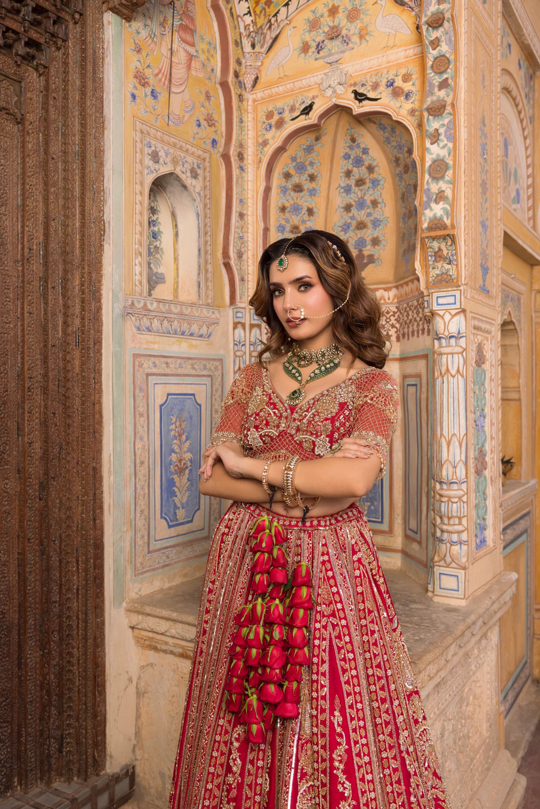 A bride with her arms crossed, pale column behind