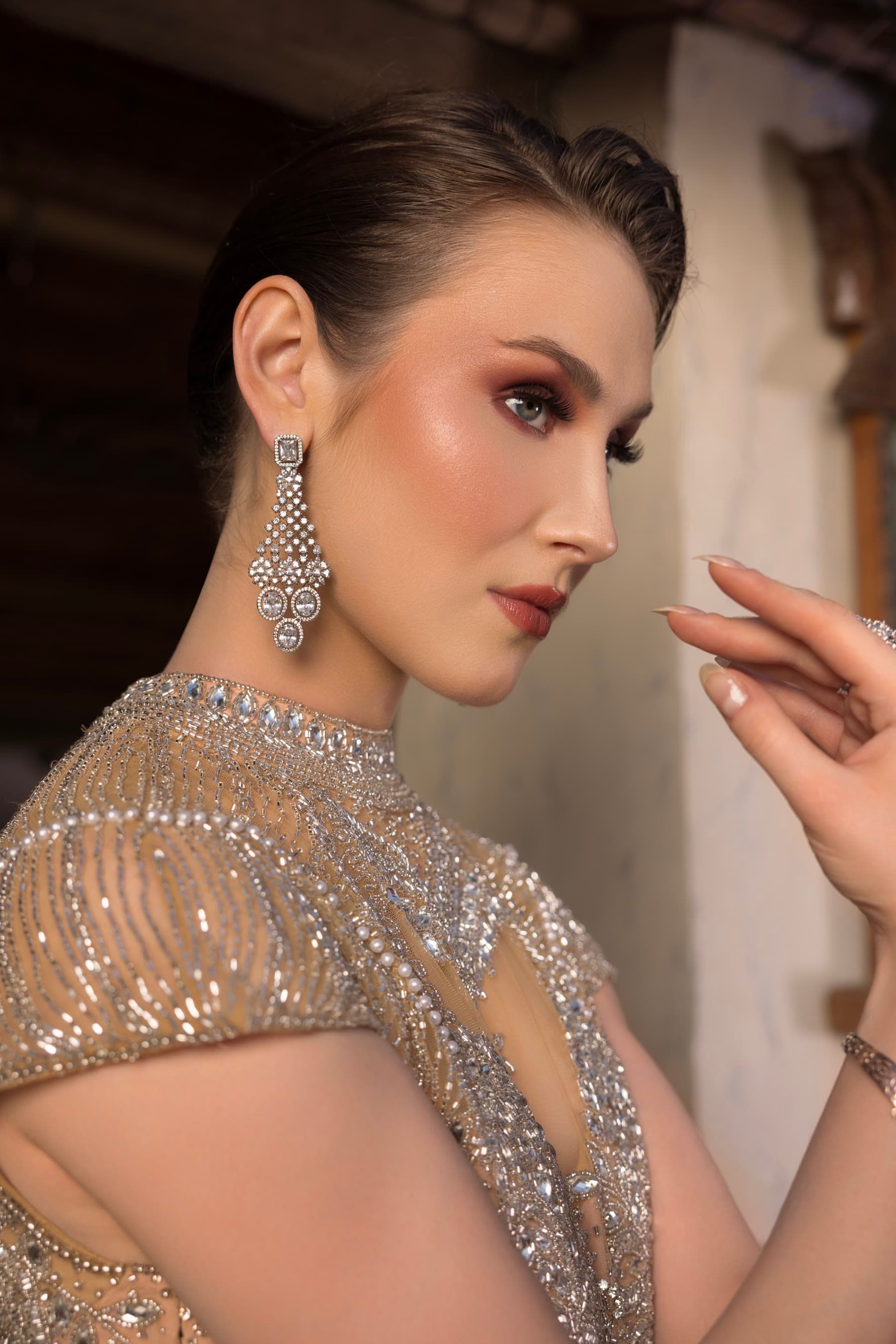 Close portrait in silver, a long crystal drop at the ear
